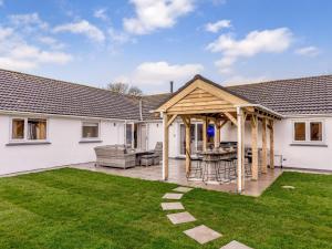 a patio with a wooden pergola in a yard at 6 Bed in Marazion 77228 in Saint Hilary