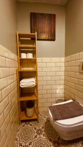 a bathroom with a toilet and a shelf with towels at The House Company in Istanbul