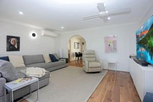 ein Wohnzimmer mit Sofa und Fernseher in der Unterkunft The Pawsome Getaway in Hawks Nest