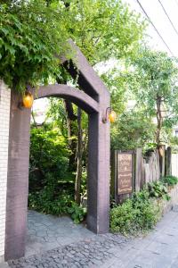 a stone archway with a sign in a park at Arbor house in Kagoshima