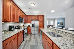 une cuisine avec des placards en bois et des appareils en acier inoxydable dans l'établissement Vista Cay 81 by Top Villas, à Orlando
