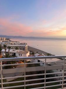 - un balcon offrant une vue sur l'océan au coucher du soleil dans l'établissement Apartamento Torre de la Roca Torremolinos, à Torremolinos