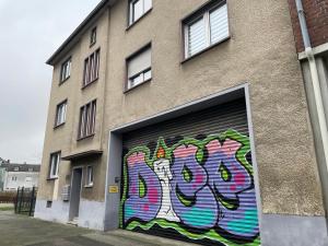 una puerta de garaje con graffiti en el lateral de un edificio en Charmante DG Whg Zentrumsnah, en Mönchengladbach