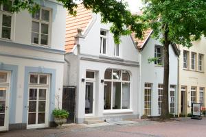 a white house with large windows on a street at Ferienwohnung Burgstübchen in Nordhorn