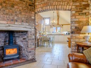 a brick fireplace in a living room with a stove at 2 Bed in Ironbridge 77771 in Leighton