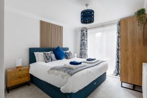 um quarto com uma cama azul e branca e uma janela em Modern, comfy Town centre gem, near beach, parking em Bournemouth