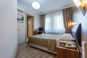 a hotel room with a bed and a television at Elasophia Hotel in Istanbul