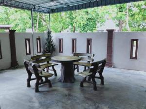 a table and two chairs and a table and benches at SUFIZA Residence in Kangar