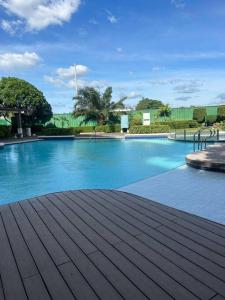 a large blue swimming pool with a wooden deck at Modern Oasis: Pool + Netflix in Manila