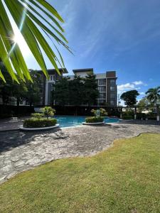 a courtyard with a building and a palm tree at Modern Oasis: Pool + Netflix in Manila