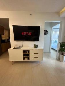 a living room with a television on the wall at Modern Oasis: Pool + Netflix in Manila