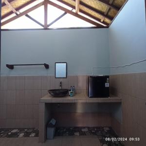 a bathroom with a sink and a mirror on a counter at Tangga Bungalows in Gili Air