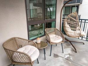 three wicker chairs and a table on a porch at Luxury 1BDR centrally located in Hollywood in Los Angeles