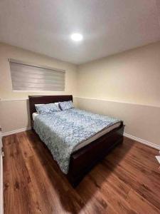 a bedroom with a bed and a wooden floor at Sabrina's Home in Delta