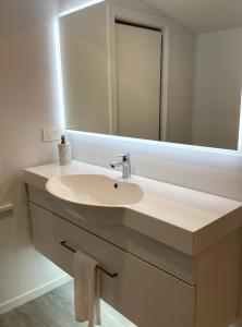 a bathroom with a sink and a mirror at Wharf Road Cottage in Coromandel Town