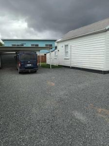 uma carrinha estacionada num parque de estacionamento ao lado de um edifício em Wharf Road Cottage em Coromandel Town