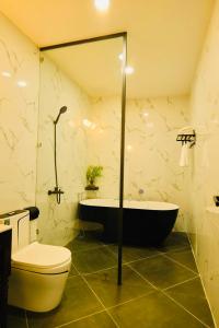 uma casa de banho com uma banheira, um WC e um lavatório. em Khách Sạn The One Hotel 2 em Cà Mau