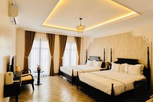 1 dormitorio con 2 camas y lámpara de araña en Khách Sạn The One Hotel 2, en Cà Mau