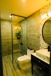 uma casa de banho com um WC, um lavatório e um espelho. em Khách Sạn The One Hotel 2 em Cà Mau