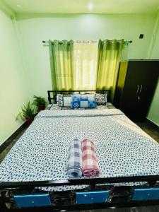 a bedroom with a large bed with two pillows on it at Deka’s Homestay in Tezpur