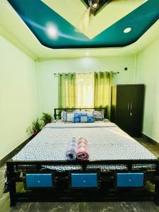 1 dormitorio con 1 cama grande y techo azul en Deka’s Homestay, en Tezpur