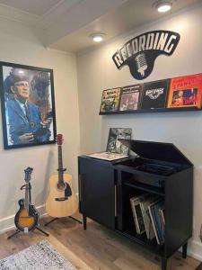 Habitación con 2 guitarras en la pared y escritorio. en Blue Moon Cottage - Music Room, Inground Pool, en Owensboro