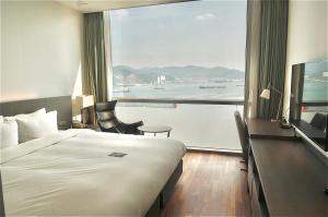 a hotel room with a bed and a large window at Sky View Hotel in Changwon