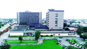 un edificio con césped verde frente a un edificio en Hotel Presidential, en Port Harcourt