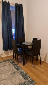 a dining room table with chairs and a window at Regent Apartments - Glasgow City in Glasgow