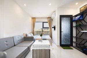 uma sala de estar com um sofá e uma mesa em Shi House - Studios Toà S503 Vinhomes Grand Park Q9 em Long Bình