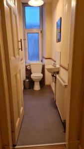 a bathroom with a toilet and a sink and a window at Regent Apartments - Glasgow City in Glasgow