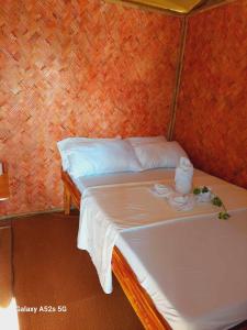 エルニドにあるKubo Inn & Beach Campの小さなベッドルーム(白いシーツ付きのベッド1台付)