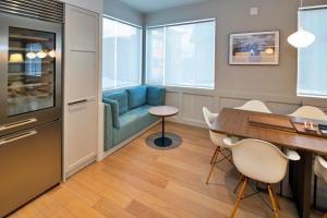 a dining room with a blue couch and a table and chairs at Shirokuma Chalets in Kutchan