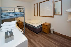 a small room with a bunk bed and a mirror at Shirokuma Chalets in Kutchan