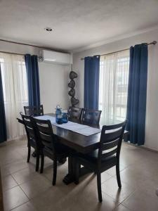 mesa de comedor con sillas y cortinas azules en Casa Balam, en Los Heroes, con alberca, en Mérida
