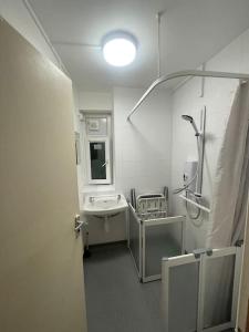 a white bathroom with a sink and a mirror at Cosy 1 bedroom flat… in London