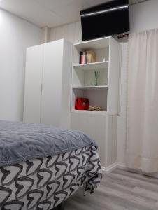 ein Schlafzimmer mit einem Bett und einem weißen Schrank in der Unterkunft apartamento genil in Granada