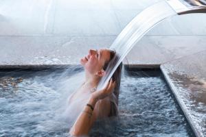 a woman is playing in a water fountain at Chalet Eden Eco Hotel, Restaurant & Wellness in La Thuile