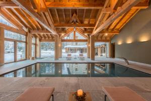 una piscina cubierta en una casa con techos de madera en Chalet Eden Eco Hotel, Restaurant & Wellness en La Thuile