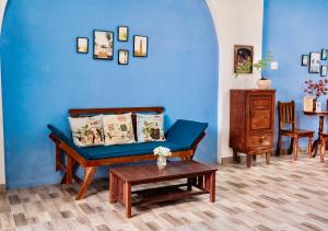 Nguyên căn Lazánia homestay ở Bình Minh Tây Ninh في Ấp Bình Trung: غرفة معيشة زرقاء مع أريكة وطاولة