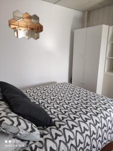 ein Schlafzimmer mit einem schwarz-weißen Bett und einem Schrank in der Unterkunft apartamento genil in Granada