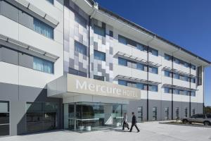 personas caminando frente a un hotel de salud en Mercure Newcastle Airport en Newcastle