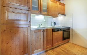 a kitchen with wooden cabinets and a sink at Awesome Apartment In Pohorje With Indoor Swimming Pool in Hočko Pohorje