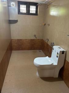a bathroom with a white toilet in a room at “Green Thumb Farm Stay” in Mundakāyam +18 photos