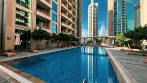 een zwembad in een gebouw met hoge gebouwen bij Magnificent Cozy 2 BR in Downtown Dubai in Dubai