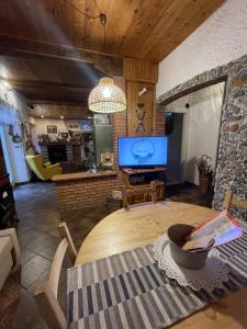 een woonkamer met een tafel en een televisie bij Casa Fiore in Ponte della Venturina