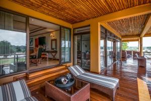a living room with glass doors and a table and chairs at Chobe Safari Lodge-East Africa Uganda in Murchison Falls National Park