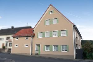 uma casa com janelas verdes fechadas numa rua em Ferienwohnung mit Terrasse - Erdgeschoss em Weilburg