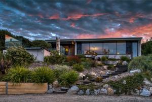 a house with a garden at sunset at SALT Luxury Couples Villa in Venus Bay