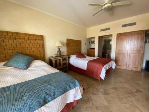 a bedroom with two beds and a ceiling fan at Entire Beachfront condo in Paradise in San José del Cabo